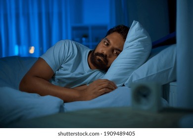 Sleeping, Insomnia And People Concept - Sleepless Indian Man Lying In Bed At Home At Night