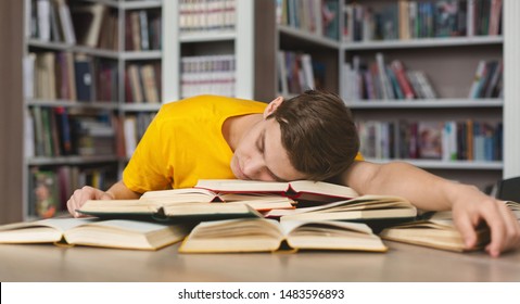 Sleeping at library. Tired caucasian guy having nap on books stack, being exhausted during preparing for exams - Powered by Shutterstock