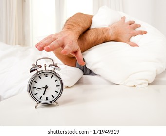 sleeping man disturbed by alarm clock early morning 