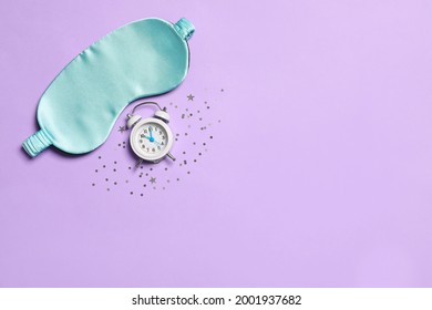 Sleeping Mask, Alarm Clock And Confetti On Violet Background, Flat Lay. Space For Text