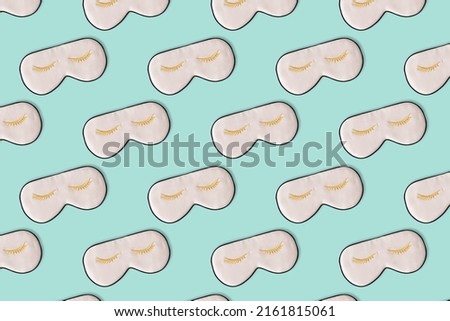 Sleeping mask pattern. Pink silk sleeping masks for eyes on pastel blue background. Creative Top view Flat lay. Concept eye protection from light for good sleep and melatonin production.