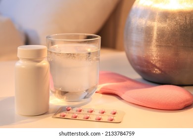 Sleeping Mask, Pills And Glass Of Water On Nightstand Indoors. Insomnia Treatment