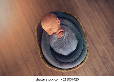 Sleeping Newborn Baby in Basket on Floor