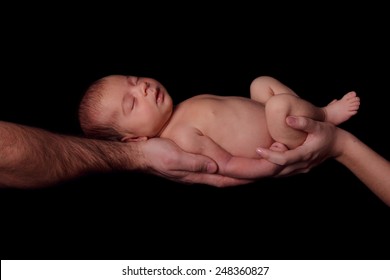 Sleeping Newborn Baby In Her Arms Mom And Dad. Concept Of Love, Protection Of Children. Studio, Black Background