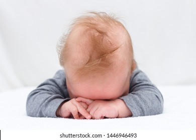 Sleeping Newborn Baby On A Blanket. Infant Boy With Hands Over His Head.