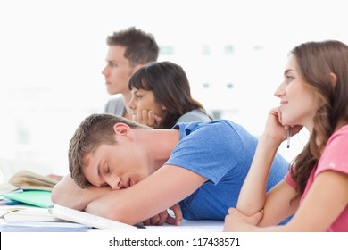 A Sleeping Student In Class As The Other Students Pay Attention And Stay Awake