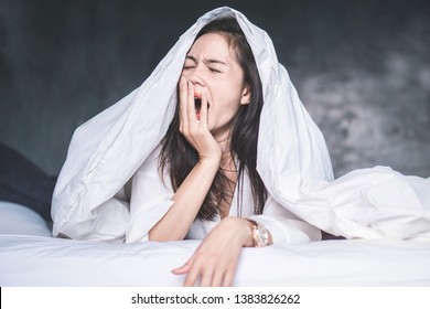 sleepless Asian woman wake up on bed and yawning feeling tired  - Shutterstock ID 1383826262