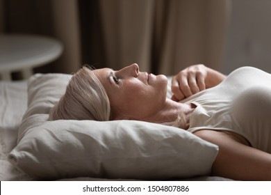 Sleepless Mature Woman With Open Eyes Lying On Soft Pillow Close Up, Suffering From Insomnia, Lack Of Sleep, Older Female Lying In Bed In The Morning, Looking Up, Thinking, Early Awakening