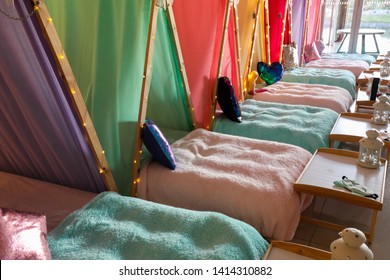 A Sleepover Party With Lots Of Colourful Teepees And Fairy Lights. 