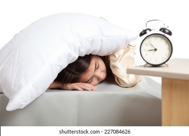 Sleepy Asian girl use pillow cover ears and alarm clock  isolated on white background