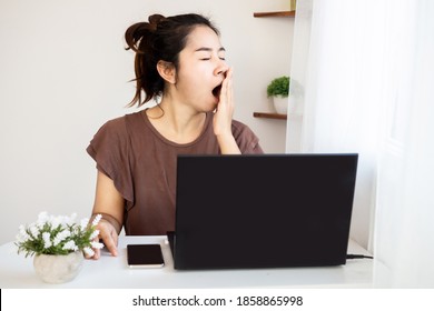 Sleepy Asian Woman Worker Yawning And Tired Working Late From Home Office 