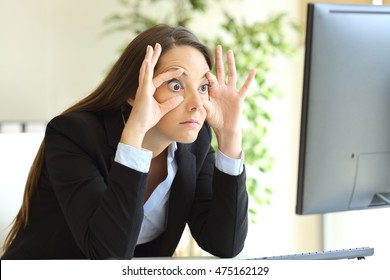 Sleepy Businesswoman Trying To Stay Awake Keeping The Eyes Opened With The Fingers Watching A Desktop Computer Monitor At Office