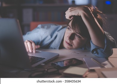 Sleepy exhausted woman working at office desk with her laptop, her eyes are closing and she is about to fall asleep, sleep deprivation and overtime working concept