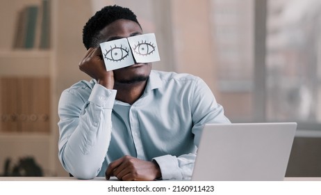 Sleepy Funny African American Office Manager Business Man Sitting At Home Workplace With Sticky Notes On Eyes Comic Young Tired Worker Has Sleeping Problem Napping At Desk Wears Glasses With Stickers