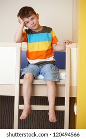 Sleepy Little Boy Sitting On Bunk Bed.