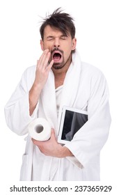 Sleepy man in a bathrobe with paper and tablet. Morning. On a white background. Close-up.