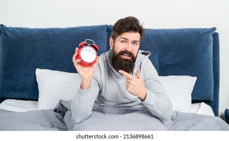 Sleepy Man Pointing Finger At Alarm Clock Being In Bed Awake, Morning