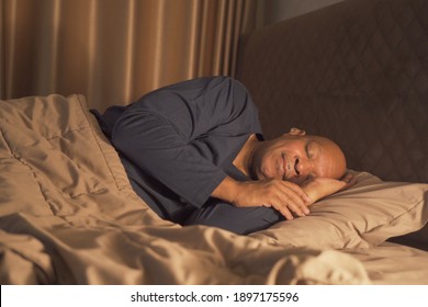 Sleepy old elderly black man yawning. African American people lying and sleeping on bed in bedroom at late night at home. Lifestyle