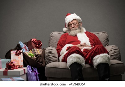 Sleepy Santa Claus taking a nap and relaxing on the armchair on Christmas Eve - Powered by Shutterstock