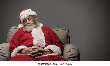 Sleepy Santa Claus taking a nap and relaxing on the armchair on Christmas Eve - Powered by Shutterstock