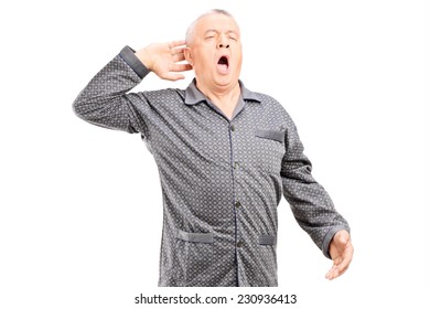 Sleepy senior in pajamas stretching on white background - Powered by Shutterstock