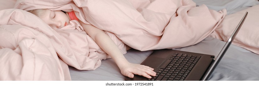 Sleepy Tired Girl Lying In Bed Under Blanket And Learning In A Virtual Online School Class. Kid Working On Laptop Internet At Home. Homeschooling Education For Children. Web Banner Header.