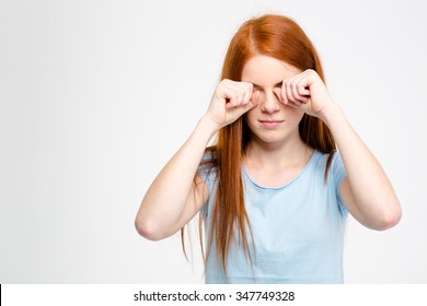 Sleepy Tired Young Woman With Long Red Hair Rubbing Her Eyes By Hands Isolated Over White Background