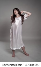 Sleepy Woman In Night Gown Yawning And Stretching Isolated On Gray Background