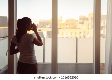 Sleepy woman stretching,drinking a coffee to wake up early in the monday morning sunrise.Starting your day.Wellbeing.Positive energy,productivity,happiness,enjoyment concept.Morning ritual - Powered by Shutterstock