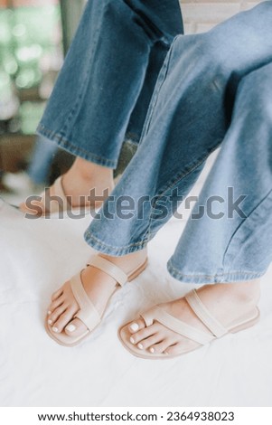 Slender beautiful female legs wearing beige shoes in studio. Street style, summer fashion trend, footwear, sandals, fashionable accessories, perfect skin, noface.
