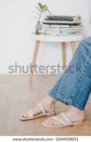 Slender beautiful female legs wearing beige shoes in studio. Street style, summer fashion trend, footwear, sandals, fashionable accessories, perfect skin, noface.