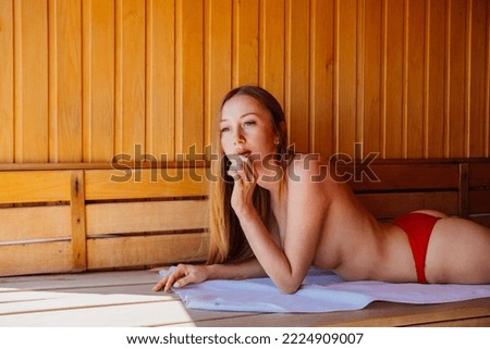 a slender and beautiful young woman topless lies on a bench in the sauna. relax in the spa center. tourism and travel.