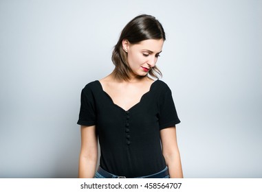 slender girl is sad, studio photo isolated on a gray background