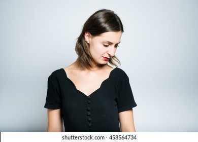 slender girl is sad, studio photo isolated on a gray background