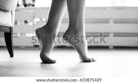 Slender girls soigne feet stand on tiptoe on the floor