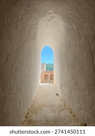 Slender window frame frames an unobstructed view of Granada's cerulean sky, evoking a sense of serene contemplation.