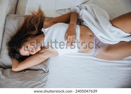 slender woman in pajamas in bedroom on bed
