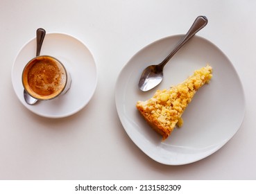 Slice of appetizing crunchy Dutch apple pie with shortcrust pastry, flavorful fruit filling and streusel crumb topping served with glass of sweet hot chocolate