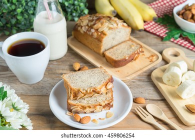 Slice Of Banana Cake Topping With Almond Slice And Banana, Coffee, Milk.