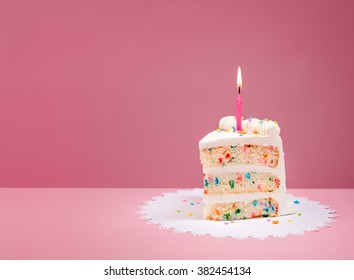 Slice of Birthday Cake with candle over a pink background.