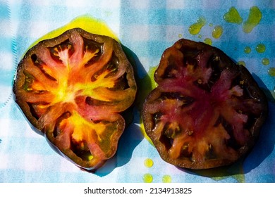 Slice Black Heirloom Tomatoes Drizzled With Olive Oil On Parchment Paper Over Gingham Check Pattern Cloth