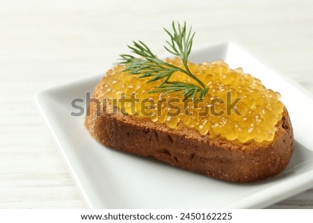 Slice of bread with pike caviar on white wooden table, closeup