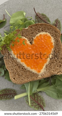 A slice of bread with salmon roe end cream cheese shaped in to heart