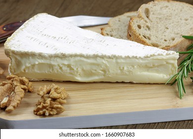 Slice Of Brie And Bread On A Cutting Board