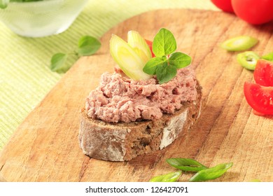 Slice of brown bread with meat spread
