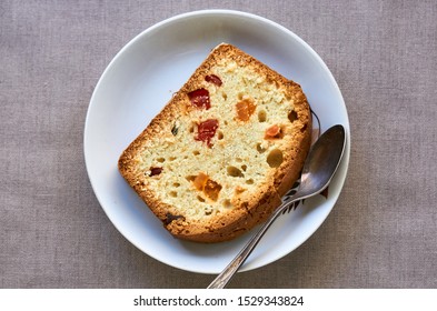 Slice Of Cake With Candied Fruit On A White Plate                               