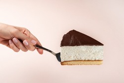 Slice Of Cake In Hand. Hand  Female Holding Slice Of Cake. Isolated Background. Side View. Sweet Birds Milk Cake
