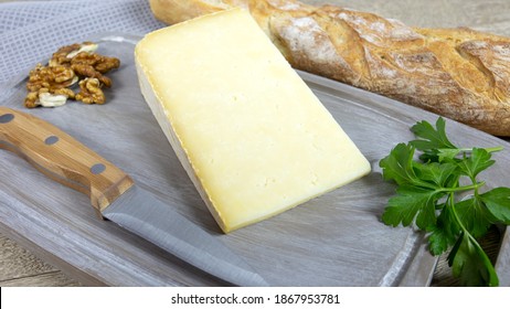 Slice Of Cantal Cheese On A Cutting Board