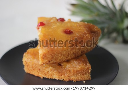 Slice of caramelised pineapple upside down cake. Home baked pineapple cake with pineapple slices are on the top. Shot on white background