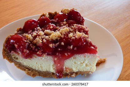 Slice Of Cheesecake With Cherry Topping And Graham Cracker Crust